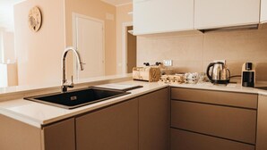 A modern kitchen with a sink, cabinets, and a coffee maker. - AFFITTACAMERE MIRA SINNI  (Episcopia)