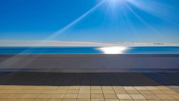 Une vue sur la mer depuis un balcon doté d’un sol carrelé et d’une balustrade.