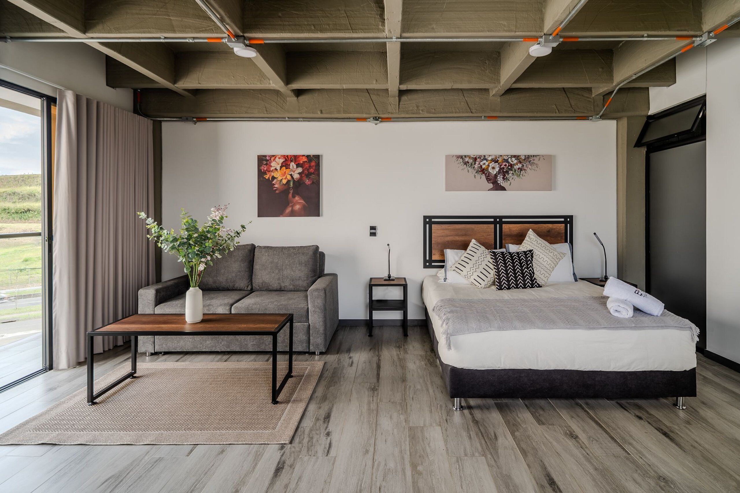 Ein modernes Schlafzimmer mit Bett, Sofa und Couchtisch.