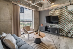 Comfort Apartment | Living area | 30-inch TV with cable channels - Epic Suites x Ahead (Pereira)