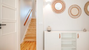 A staircase with wooden steps and a handrail, leading to a white door. - GuestReady - A pinch of heaven in Lisbon (Lisbon)
