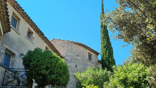 A stone staircase leading up to a building with a tiled roof, surrounded by lush greenery and a clear blue sky. - Air-conditioned Mazet Romarin - private terrace- shared swimming pool- Vallée des Baux (Paradou)