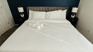 A neatly made bed with white linens, two bedside lamps, and a headboard. - Sandy Retreat for family and groups Austin (Round Rock)