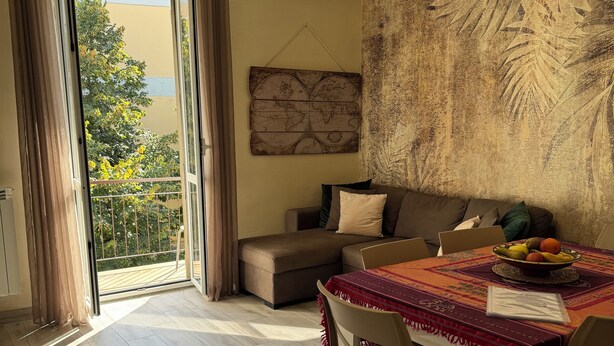 A dining area with a table set for two, a sofa, and a world map artwork on the wall. - Harmony in the green Veronese (Verona)