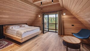 A wooden-paneled bedroom with a bed, a small table, and a chair. - Siedlisko Milachowo luxury wellness (Brusy)