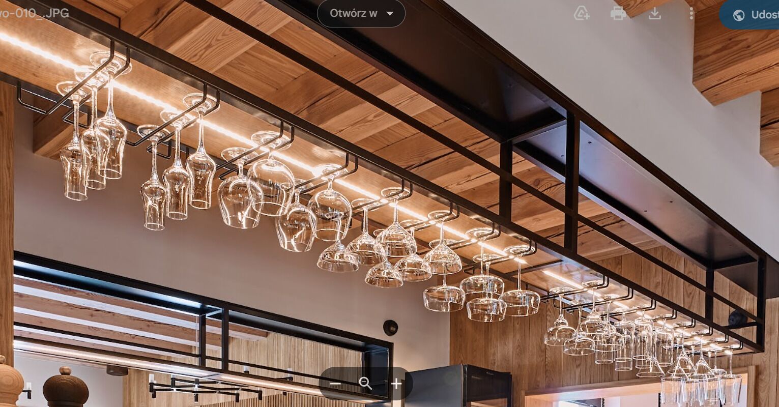 A modern interior with a wooden ceiling and a series of hanging glass light fixtures.