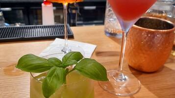 A bar area with a variety of drinks, including a martini and a cocktail with an orange slice garnish.