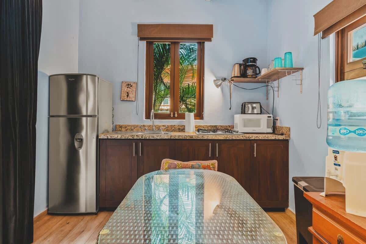 A compact kitchen with a refrigerator, microwave, and water dispenser.