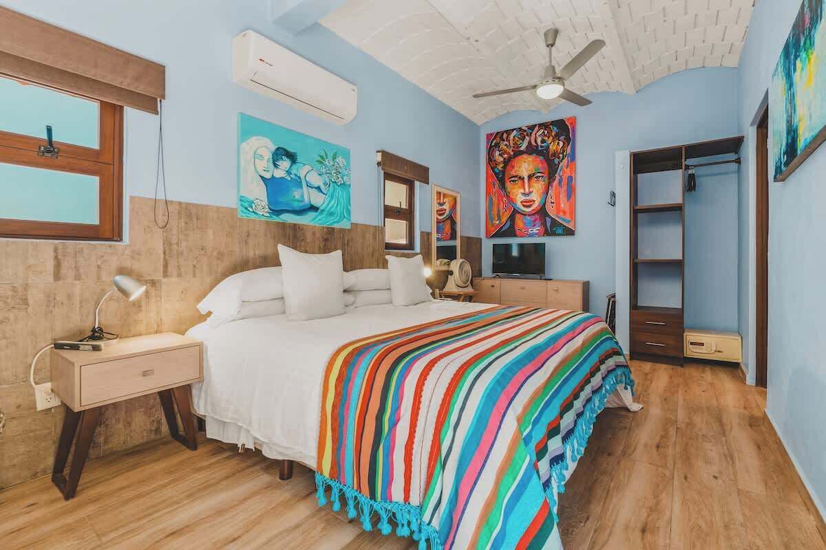 Un dormitorio con cama, mesita de noche y ventilador de techo.