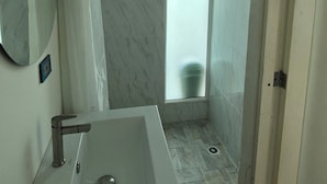 Et badeværelse med en marmorvask, bruser og toilet.