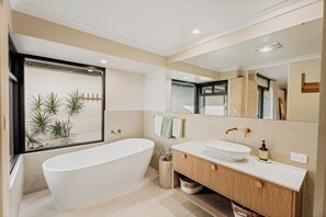 A modern bathroom with a freestanding bathtub, a vanity with a sink, and a large mirror. - Wildwood—Luxe Vineyard Retreat with Tranquil Views (Yallingup Siding)