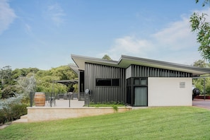 A modern house with a flat roof, a covered outdoor area, and a well-maintained lawn. - Wildwood—Luxe Vineyard Retreat with Tranquil Views (Yallingup Siding)
