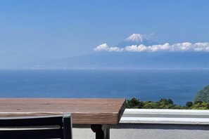 A table with a view of a mountain and ocean. - Nishi-izu Glamping Tenkuu-Terrace (Numazu)