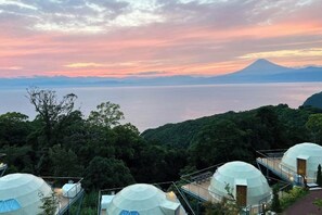 A view of dome-shaped accommodations with a mountain and lake in the background. - Nishi-izu Glamping Tenkuu-Terrace (Numazu)