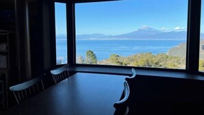 A room with a large window offering a view of a mountain and a body of water. - Nishi-izu Glamping Tenkuu-Terrace (Numazu)