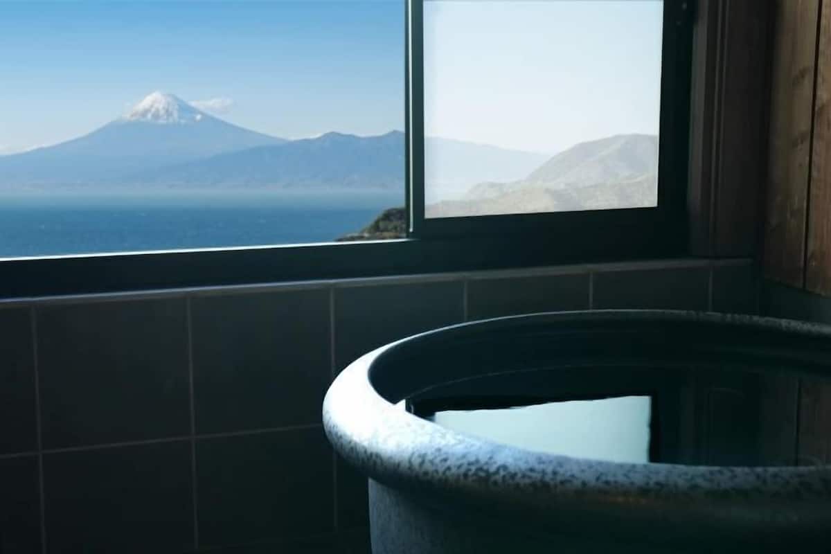 A window with a view of a mountain and a body of water.