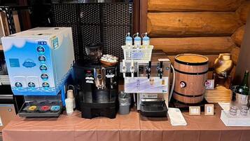 Uma estação de café com máquina de café, máquina de expresso e jarros de café.