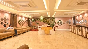 Un hall d’hôtel comprenant un comptoir d’accueil, un espace salon et un mur décoratif.