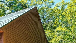 Eine Holzhütte mit einer Holzterrasse und einer blauen Tür.