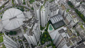 A high-rise building with a circular structure, surrounded by other tall buildings, indicating a dense urban area.