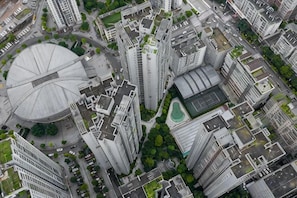 A high-rise building with a circular structure, surrounded by other tall buildings, indicating a dense urban area. - Tianshun Apartment (Chongqing)