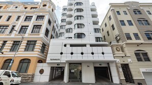 Un edificio moderno con un diseño arquitectónico único, que cuenta con varios balcones y una entrada destacada.