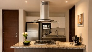 Una cocina moderna con una isla central, electrodomésticos de acero inoxidable y taburetes de madera.