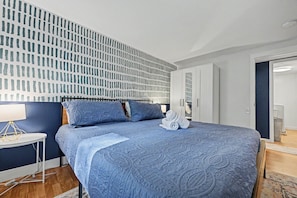 Ein Hotelzimmer mit Bett, Nachttisch, Kleiderschrank und Badezimmer.