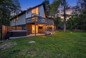 Ett modernt hus i två våningar med en balkong, ett bubbelbad och en uteplats.