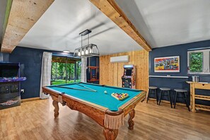 A pool table with a wooden frame, a ceiling fan, and a wall-mounted air conditioner. - Newly renovated house in Lake Harmony w/ Hot Tub, Gameroom & Summer Beach Access (Lake Harmony)