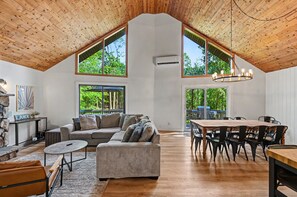 Un loft espacioso con techos altos, ventanas grandes, un comedor y una zona de estar acogedora.