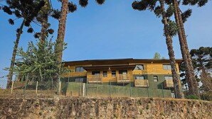 A modern two-story building with a wooden facade, large windows, and a balcony.