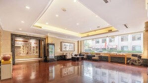 A spacious lobby with a polished floor, a reception desk, and framed artwork on the walls. - Post And Telecommunication Mansion (Taiyuan)