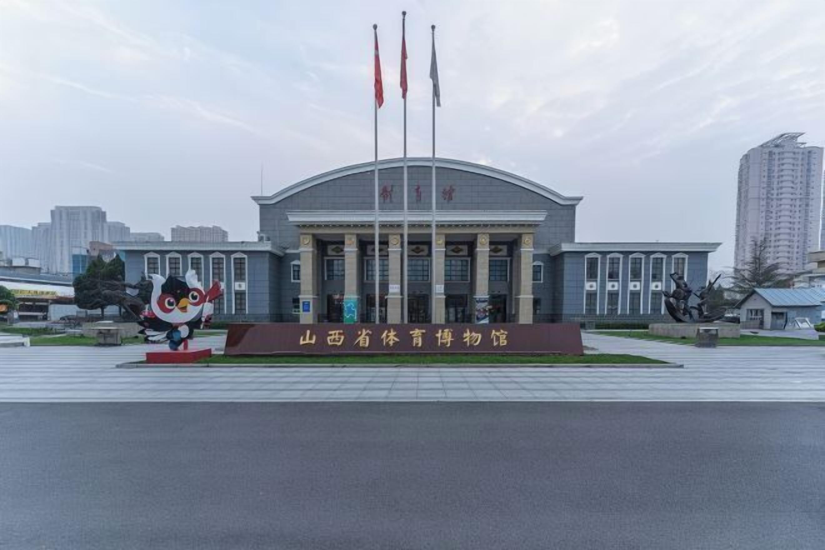 A large building with a curved roof and multiple flagpoles.