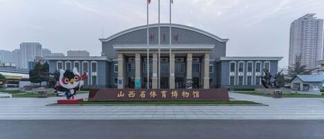 A large building with a curved roof and multiple flagpoles.