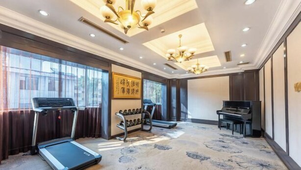 A room with a treadmill, a piano, and a shoe rack. - Post And Telecommunication Mansion (Taiyuan)