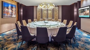 A conference room with a round table, chairs, and a chandelier. - Post And Telecommunication Mansion (Taiyuan)