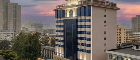 Een hoog hotel met meerdere verdiepingen, een opvallende entree en uitzicht op de omliggende stad.