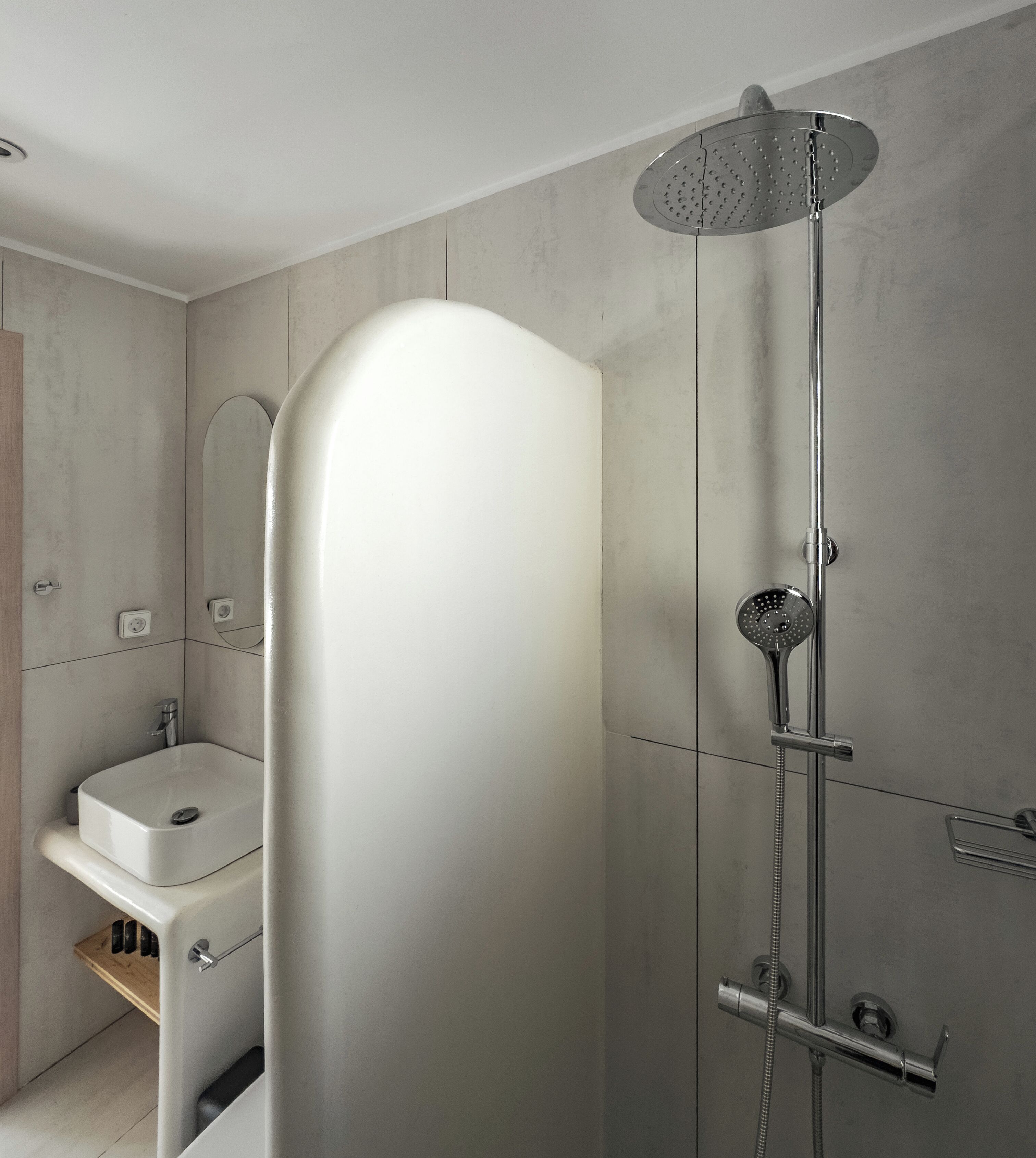 A modern bathroom with a shower, a sink, and a mirror.