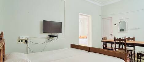 Camera da letto con un letto, una scrivania, una sedia e due ventilatori a soffitto.