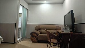 A modern living room with a sofa, a TV, and a desk. - Anyuan Jingcheng Business Hotel (Anyuan)