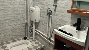 A bathroom with a toilet, bidet, sink, and a mirror. - Anyuan Jingcheng Business Hotel (Anyuan)