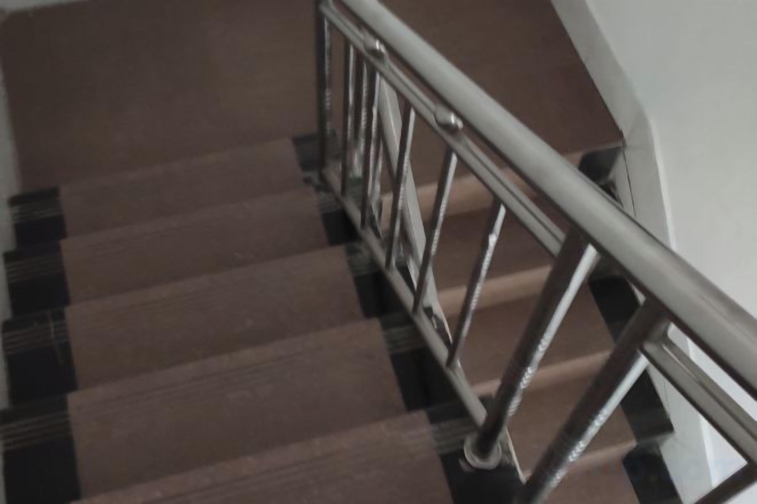 A staircase with a metal handrail and wooden steps.