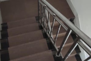 A staircase with a metal handrail and wooden steps.