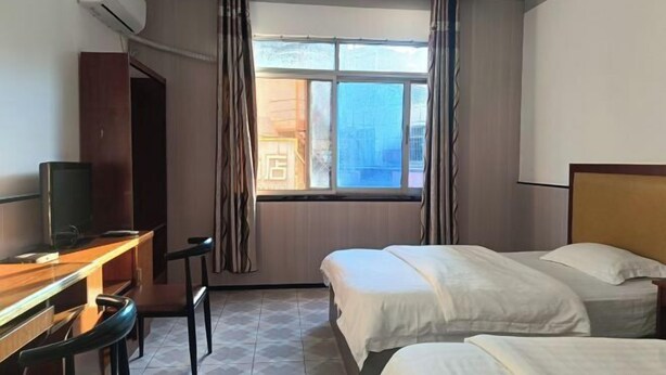 A hotel room with two beds, a desk with a chair, and a TV. - Anyuan Jingcheng Business Hotel (Anyuan)