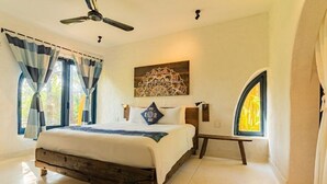 A bedroom with a wooden bed, a ceiling fan, a decorative wall piece, and a window with curtains. - Flow House 3BR Oceanview An Bang Beach  (Da Nang)