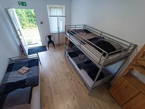 A dormitory room with bunk beds, a desk, and a chair. - Hostel Gransee (Gransee)
