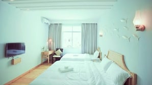 Ein Hotelzimmer mit zwei Betten, einem Fernseher, einem Schreibtisch und einem Fenster mit Vorhängen.