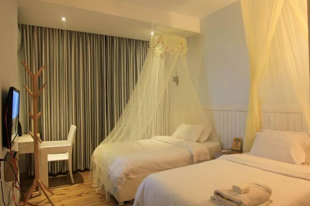 Een hotelkamer met twee bedden, een bureau en een televisie.