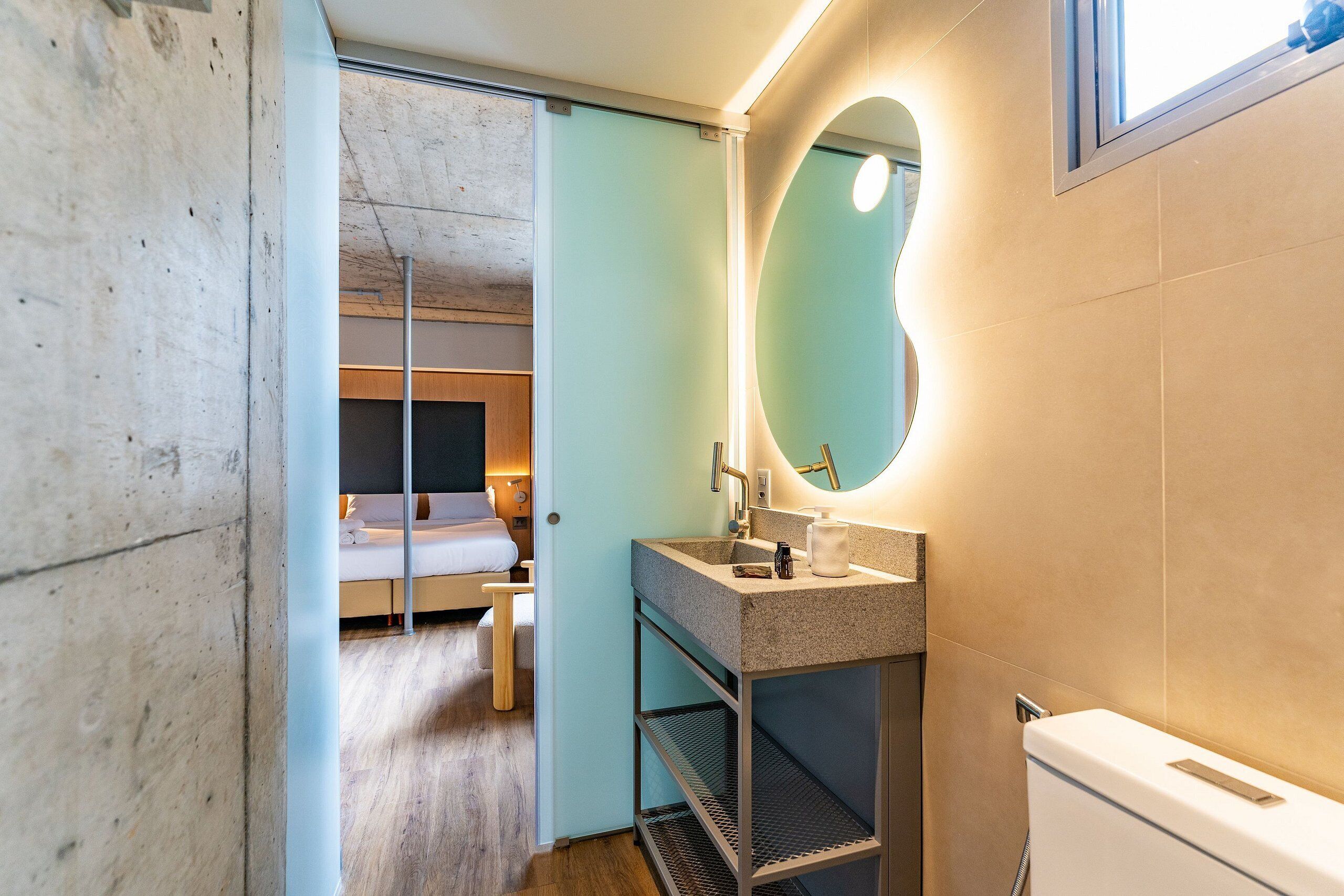 A modern bathroom with a sink, mirror, and toilet.